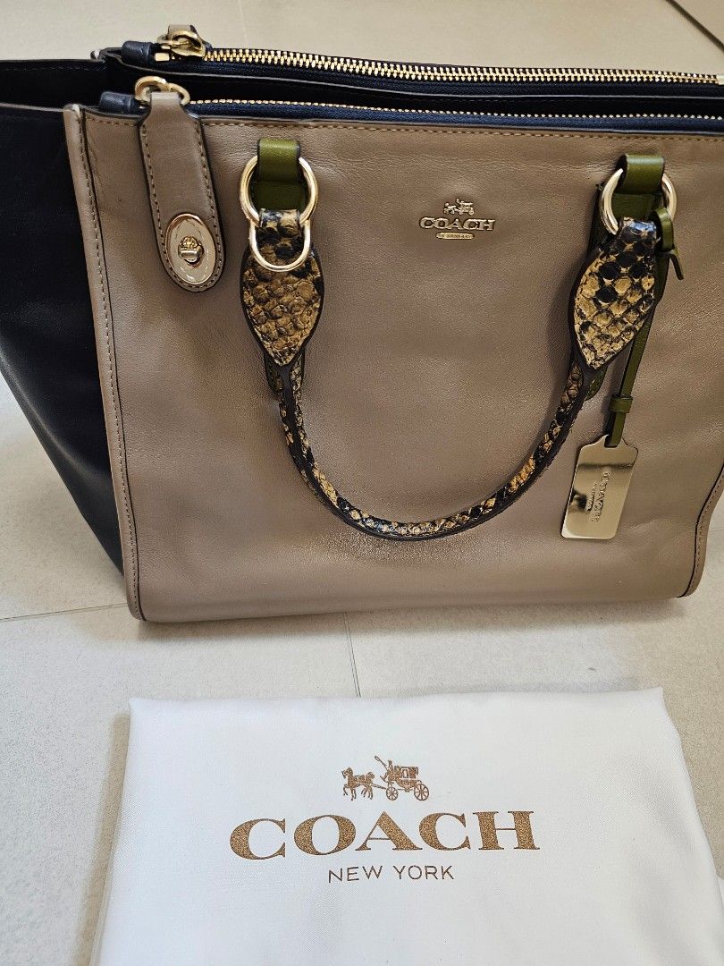 Coach 拼色真皮手提/斜孭袋(內可擺放電腦) （分類：手袋及銀包）位於 Hong Kong。 由 mayd32 提交（商品編號 1449145398，圖片 1）。簡介： - 很少使用的閒置品，保養新淨 - Coach 拼色手袋，啡色配黑色 - 手柄位設有獨特蛇紋裝飾 - 袋面印有經典 Coach 標誌及精緻金屬扣設計，增添亮點 - 附有原裝防麈袋及可拆卸長肩帶，方便斜孭。