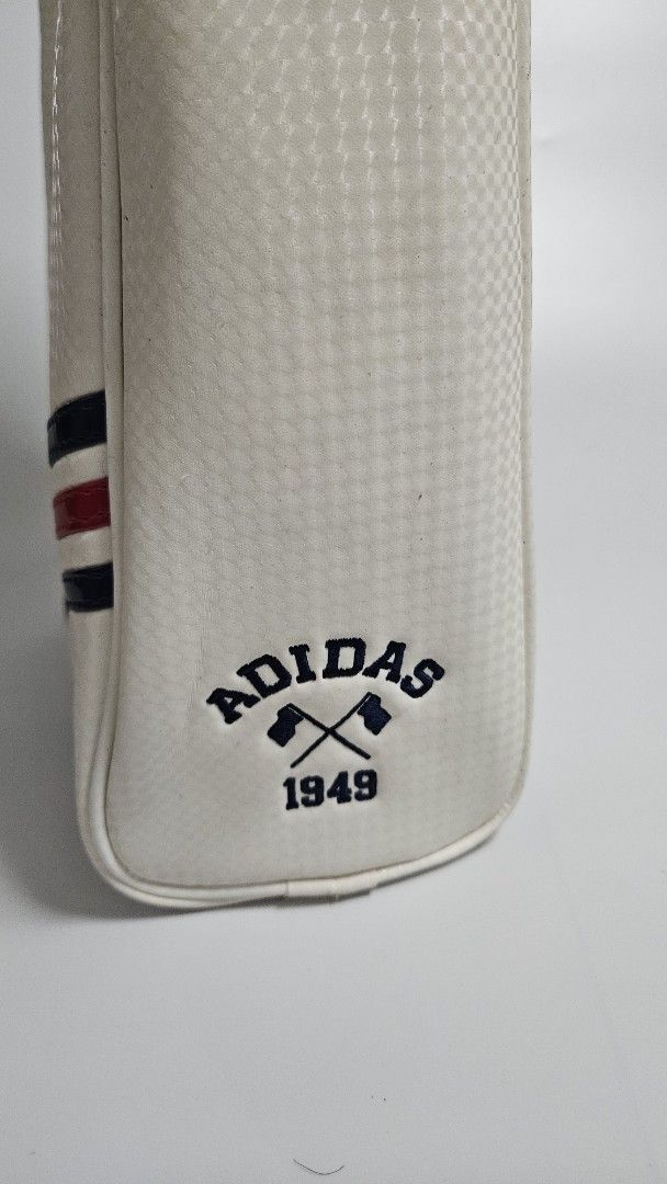 Adidas White shoe case (Category: Backpacks) located in Alfonso. Submitted by jbcamet (Listing ID 1449192692, Image 3). Description: - Classic white Adidas bag - Features navy and red stripe accents - Secure zip closure - Convenient strap for carrying - Embroidered Adidas logo on the front - Adidas 1949 logo detail on the side - Ideal for storing small items.