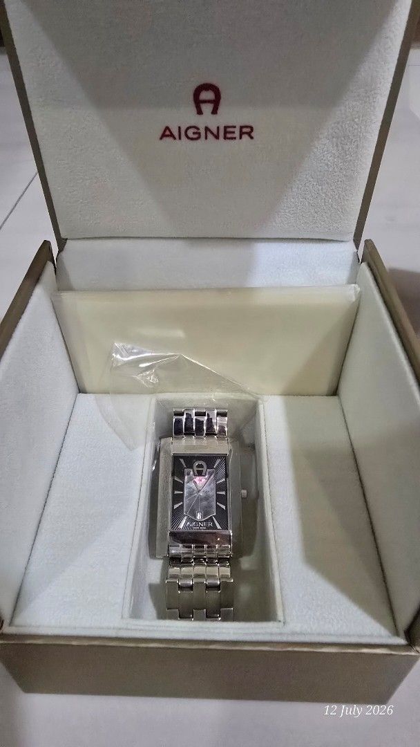 AIGNER Rectangular Watch (Category: Watches) located in Singapore. Submitted by iamhappy72 (Listing ID 1449153797, Image 1). Description: - Authentic Aigner watch - Silver metal strap - Rectangular watch face - Black dial with silver hour markers - Includes original watch box - Perfect for everyday or special occasions - Quartz but no battery inside - Goods sold is non refundable .