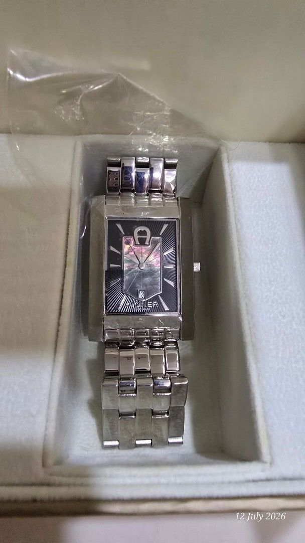 AIGNER Rectangular Watch (Category: Watches) located in Singapore. Submitted by iamhappy72 (Listing ID 1449153797, Image 2). Description: - Authentic Aigner watch - Silver metal strap - Rectangular watch face - Black dial with silver hour markers - Includes original watch box - Perfect for everyday or special occasions - Quartz but no battery inside - Goods sold is non refundable .