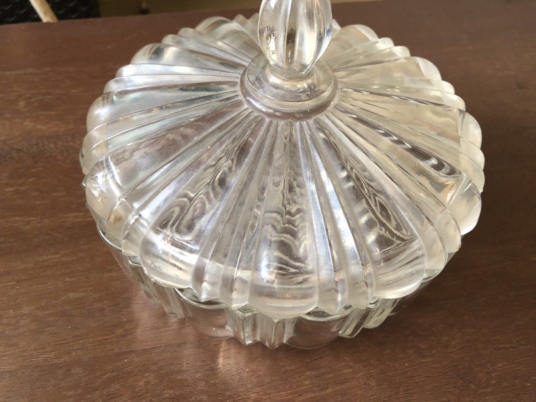 Anchor Hocking Clear Glass Candy Dish with Lid (Category: Other Kitchenware & Tableware) located in Pasig City. Submitted by vintagely (Listing ID 1449216018, Image 2). Description: - Beautiful clear glass candy dish with lid. - Features a lovely ribbed design on the lid. - Starburst pattern on the base. - Great for storing sweets or as a decorative piece. - Adds a classic touch to any table. - Measures approximately 7” inches in diameter and 51/