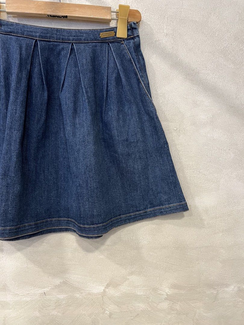 Burberry Blue Label Denim Skirt (Category: Skirts) located in Manila. Submitted by -handpick- (Listing ID 1449282520, Image 3). Description: - Burberry Blue Label denim skirt - Features front pleats for a flattering flared silhouette - Classic blue wash for versatile styling - Ideal for casual everyday wear - Effortlessly pairs with various tops and footwear Size : 38 Dimensions : Length : 18 inches Waistline : 26 inches.