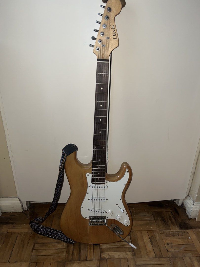 Davis Electric Guitar with Strap (Category: Musical Instruments) located in Makati City. Submitted by shujiscloset (Listing ID 1449204135, Image 1). Description: Davis electric guitar - Natural wood finish - Comes with a patterned strap - Ideal for beginners or as a backup guitar WITH FREE capo, string cleaner, cables Negotiable for serious buyers only.