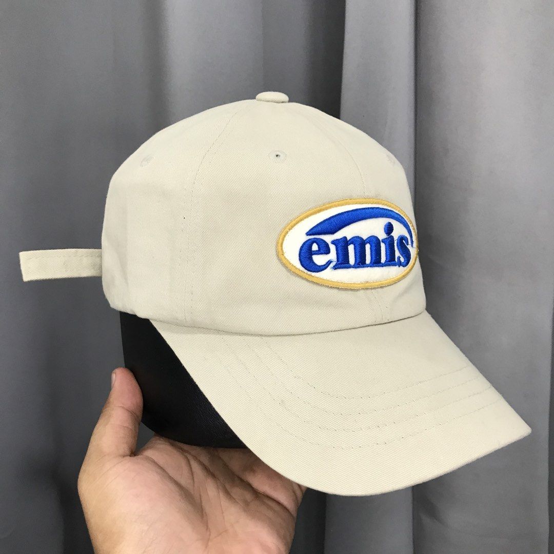 EMIS Cap Beige Blue Oval Logo Adjustable Strap (Category: Caps & Hats) located in Ozamiz City. Submitted by ClassicDrip (Listing ID 1449233746, Image 2). Description: - Beige cap with embroidered EMIS logo on the front. - Distinctive blue and yellow oval design. - Adjustable strap at the back for a comfortable, customized fit. - Simple, classic style suitable for everyday wear. - "E17 - 22" detail visible at the back..