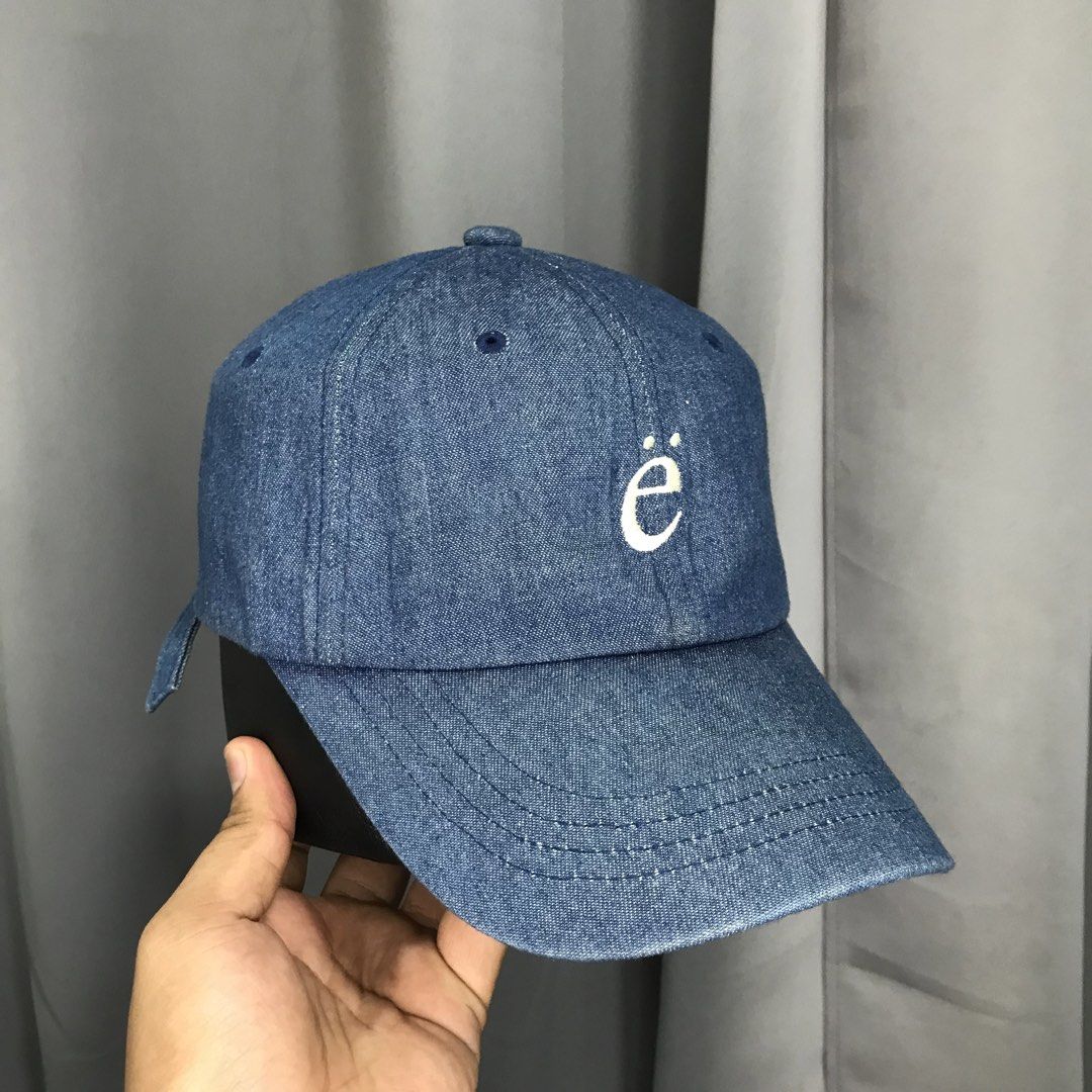 EMIS Denim Baseball Cap with Embroidered 'ë' Logo (Category: Caps & Hats) located in Ozamiz City. Submitted by ClassicDrip (Listing ID 1449245250, Image 2). Description: - Brand: EMIS - Style: Classic blue denim baseball cap - Features: White embroidered 'ë' logo on front, 'emis' on back - Fit: Adjustable strap for a customized fit - Occasion: Perfect for casual wear.