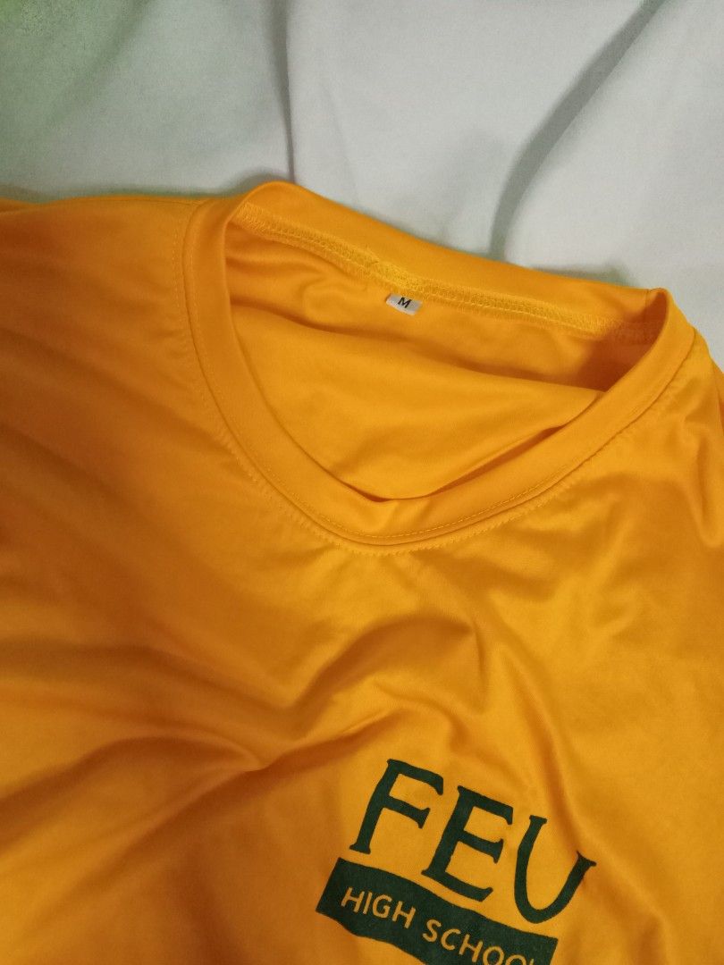 FEU Senior High School PE T-shirt (Category: Shirts) located in Manila. Submitted by fleurin (Listing ID 1449169465, Image 2). Description: - Yellow t-shirt with FEU High School logo - Size: Medium (M) - Short sleeves - Comfortable fabric - Ideal for school events or casual wear.