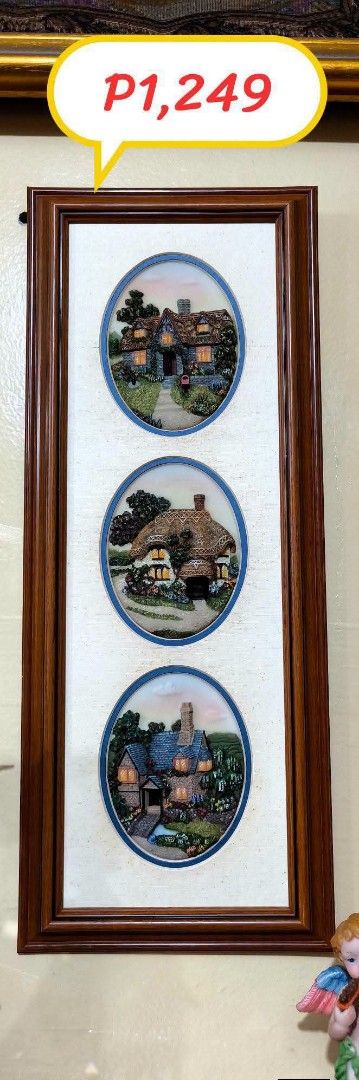 Framed Triple Oval Cottage Scene Wall Art (Category: Wall Decor) located in Quezon City. Submitted by louidanny3 (Listing ID 1449225725, Image 1). Description: - Set of 3 framed wall art pieces - Features charming cottage scenes with thatched roofs - Detailed artwork with warm lighting - Rustic and cozy aesthetic - Wooden frame complements the art - Ready to hang.