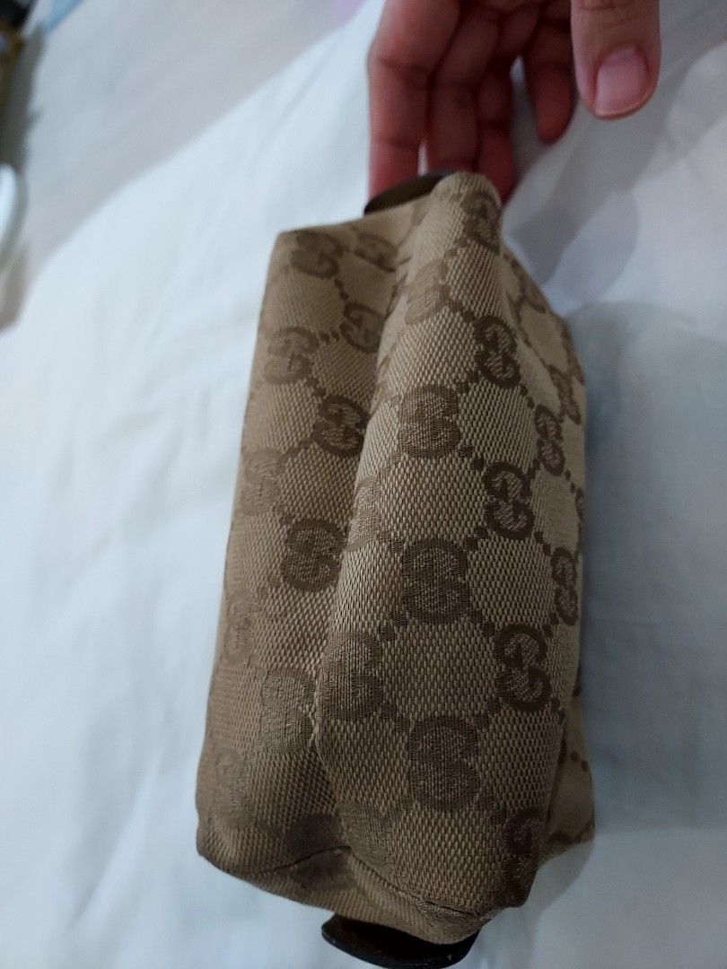 Gucci GG Monogram Pouch Cosmetic Bag (Category: Luxury Bags & Wallets) located in Paranaque City. Submitted by andim8 (Listing ID 1449198774, Image 3). Description: - Authentic Gucci pouch - Classic GG monogram canvas (beige/brown) - Zip closure with unique heart-shaped zipper pull - Interior 'Gucci Made in Italy' tag - Ideal for makeup or small essentials - Approximate dimensions: 6 inches (length) x 3 inches (height).