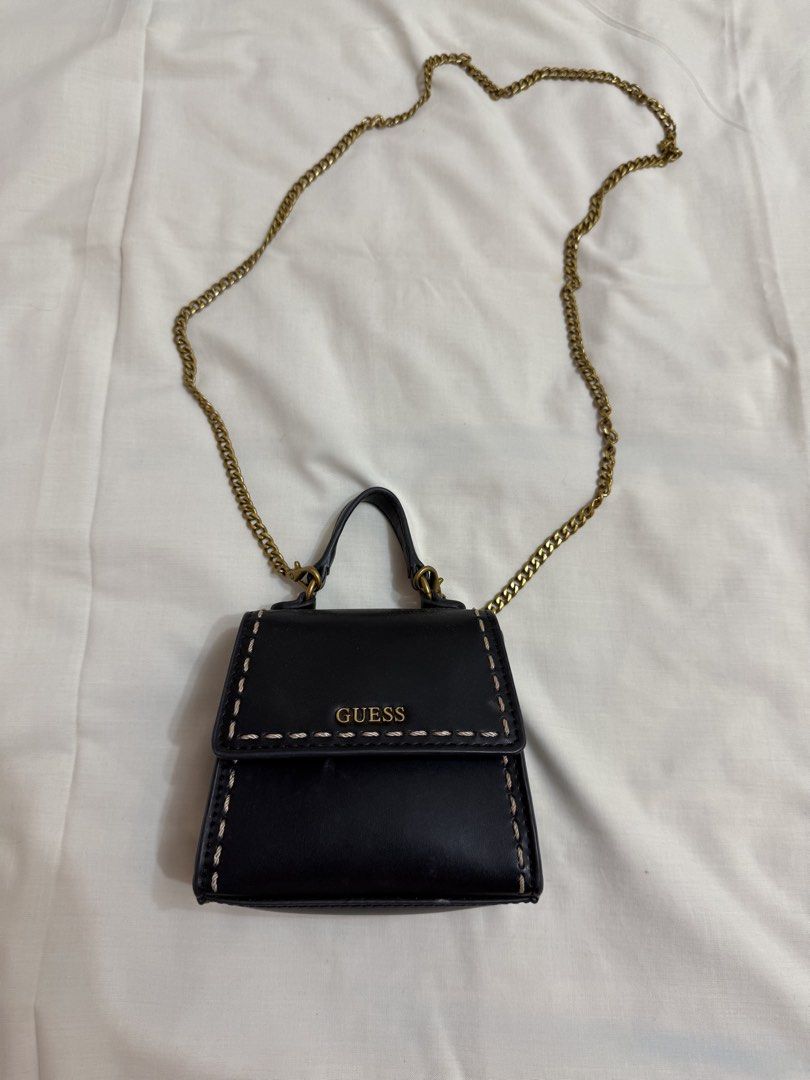 Guess Black Mini Bag with Gold Chain (Category: Luxury Bags & Wallets) located in Makati City. Submitted by haggleandshop (Listing ID 1449255936, Image 1). Description: - Cute black mini bag from Guess - Gold chain strap and top handle - Stitching detail on the front flap - Small size, ideal for essentials - Interior features Guess logo - Gold hardware - Versatile for night outs or casual wear.