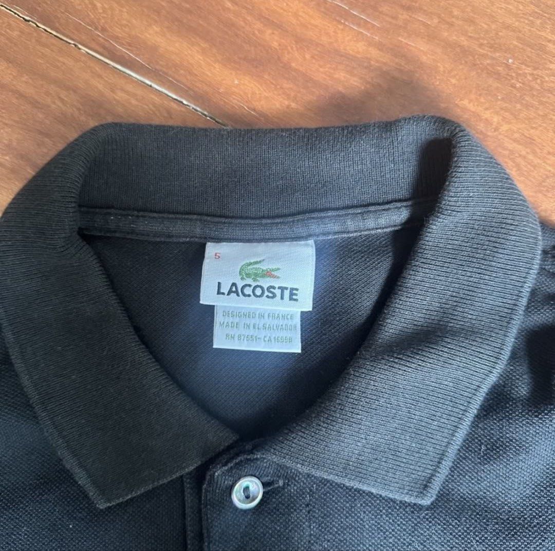 Lacoste Black Polo Shirt (Category: Tshirts & Polo Shirts ) located in San Juan City. Submitted by gj10_ (Listing ID 1449166215, Image 2). Description: - Classic black Lacoste polo shirt - Iconic green crocodile logo on chest - Made in El Salvador - Size 5 - Ideal for casual or smart casual outfits.