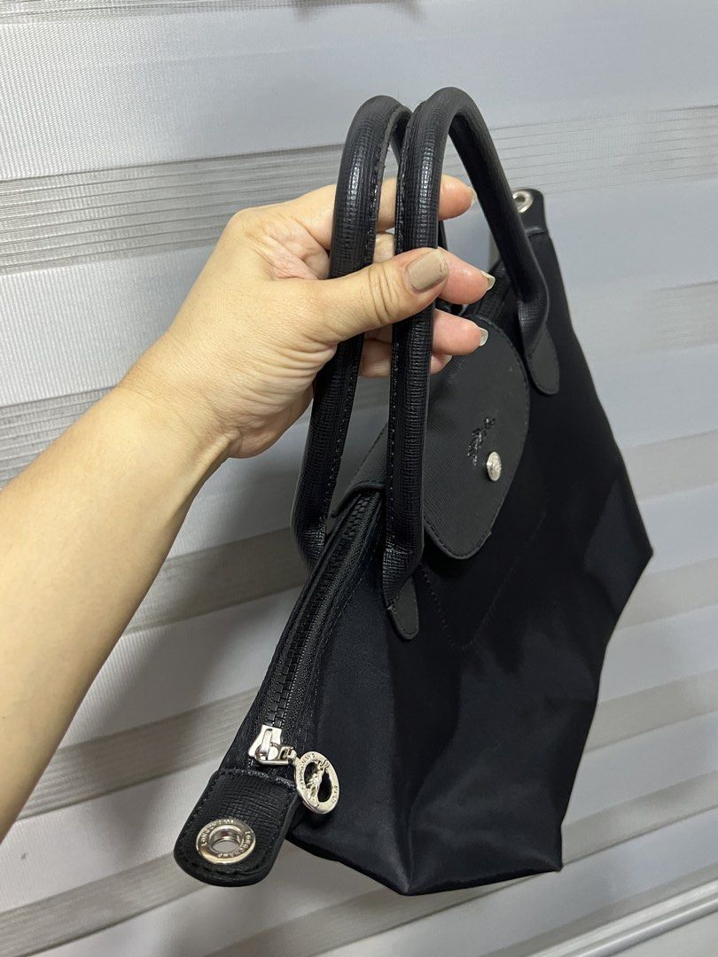 Longchamp Le Pliage Neo Top Handle Bag Black (Category: Luxury Bags & Wallets) located in Las Pinas. Submitted by maple0305 (Listing ID 1449265987, Image 2). Description: - Classic black Longchamp bag - Durable nylon body with leather handles and trim - Secure zipper closure with snap-button flap - Spacious main compartment inside - Ideal for everyday use and easy to carry.