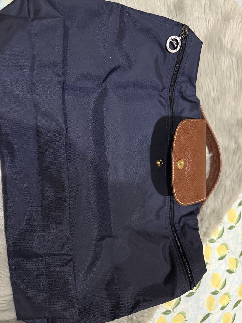 Longchamp Le Pliage Tote Bag Navy Blue (Category: Luxury Bags & Wallets) located in Manila. Submitted by b5l10ilocos (Listing ID 1449185768, Image 3). Description: - Classic Longchamp tote bag - Color: Navy blue nylon with brown leather trim - Closure: Zip with snap button flap - Iconic embossed horse logo on leather - Ideal for everyday use or travel - Folds flat for easy storage.