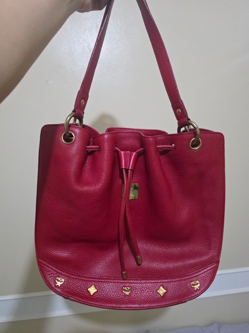 MCM München Red Leather Drawstring Bucket Bag (Category: Luxury Bags & Wallets) located in Las Pinas. Submitted by andthelike (Listing ID 1449251992, Image 1). Description: - Authentic MCM red leather bucket bag - Secure drawstring closure - Elegant gold-tone hardware - Signature MCM logo plate on the front - Two charming red leather tassels with gold caps - Ideal for everyday style and practicality - A timeless MCM classic.