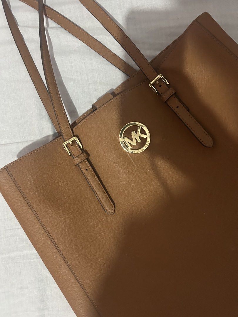 Michael Kors Brown Leather Tote Bag (Category: Tote Bags) located in Makati City. Submitted by swifttttt (Listing ID 1449165064, Image 1). Description: - Classic brown leather Michael Kors tote bag - Gold MK logo hardware on the front - Adjustable shoulder straps with buckle detail - Spacious interior, ideal for everyday use - Simple, chic, and versatile design for work or casual outings.