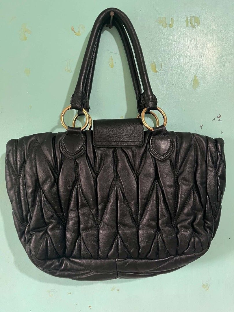 Miu Miu Black Leather Quilted Handbag (Category: Luxury Bags & Wallets) located in Abucay. Submitted by chinithou (Listing ID 1449327182, Image 2). Description: - Miu Miu black leather handbag - Stylish quilted design - Elegant gold hardware accents - Luxurious purple satin interior lining - Convenient interior zippered pocket - Comfortable black leather handles with gold ring details - Ideal for everyday chic and versatile use.