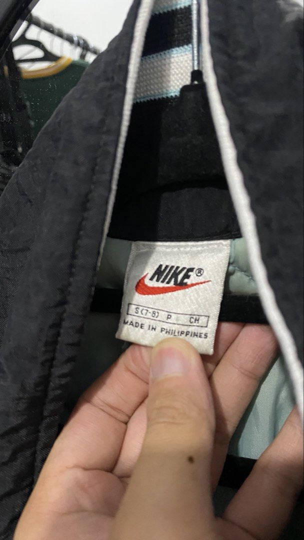 Nike Black Jacket with Large "NIKE" Logo on Back (Category: Coats, Jackets and Outerwear) located in Porac. Submitted by moethrifter (Listing ID 1449167055, Image 2). Description: - Classic black Nike jacket - Bold "NIKE" logo across the back - Embroidered Nike swoosh on the chest - Easy snap button closure - Comfortable light blue inner lining - Proudly made in the Philippines.
