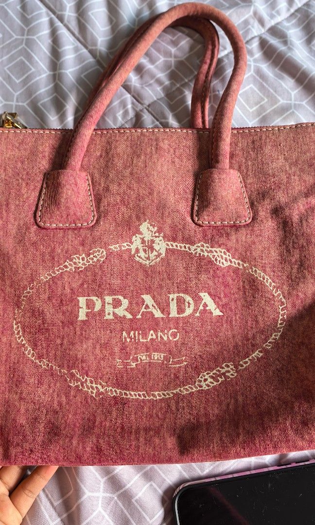Prada canapa tote (denim like) (Category: Bags & Wallets) located in Nusajaya. Submitted by emmajani (Listing ID 1449106950, Image 3). Description: denim material got from a thrift reseller in great condition lampo zipper in pink-peach color can fit bottle, ipad, macbook, books etc suitable for moms, or for working bag lightweight. super easy to bring anywhere..