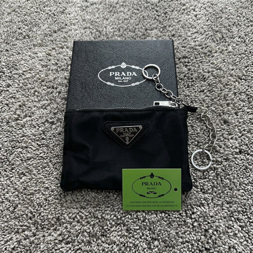 PRADA Nylon Mini Pouch Keychain | PRE-ORDER (Category: Luxury Bags & Wallets) located in Manila. Submitted by thegwpvault (Listing ID 1449182018, Image 2). Description: ✨ PRE-ORDER ONLY A sleek and stylish mini nylon pouch with a keychain attachment—perfect for coins, earbuds, lip balm, cards, or small everyday essentials. Inclusions: • Prada Nylon Mini Pouch Keychain • Prada Presentation Box • Certificate/Tag (as shown) 📦 Condition: Brand New �