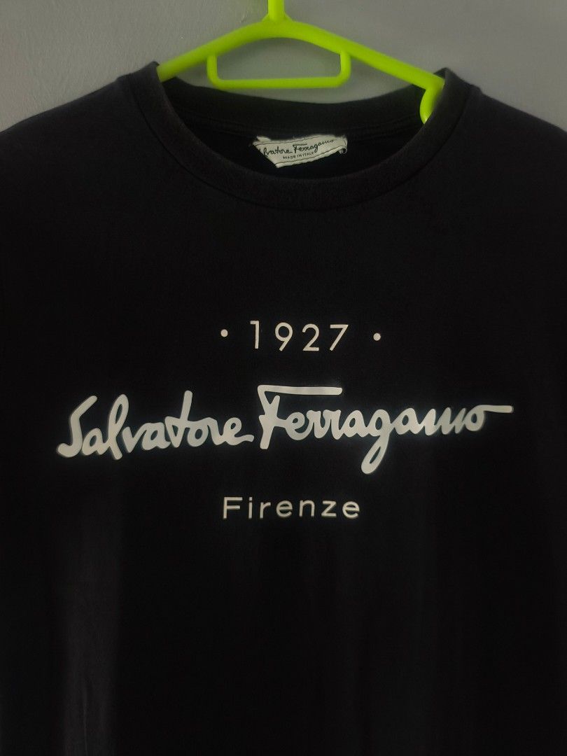 Salvatore Ferragamo t-shirt (Category: Announcements) located in Cagayan de Oro. Submitted by jamesb2854 (Listing ID 1449156311, Image 2). Description: This black Salvatore Ferragamo t-shirt features a distinctive "1927" logo graphic on the chest. Good condition Color rate 7.5/10 Dimes: 16.5×25 inches.