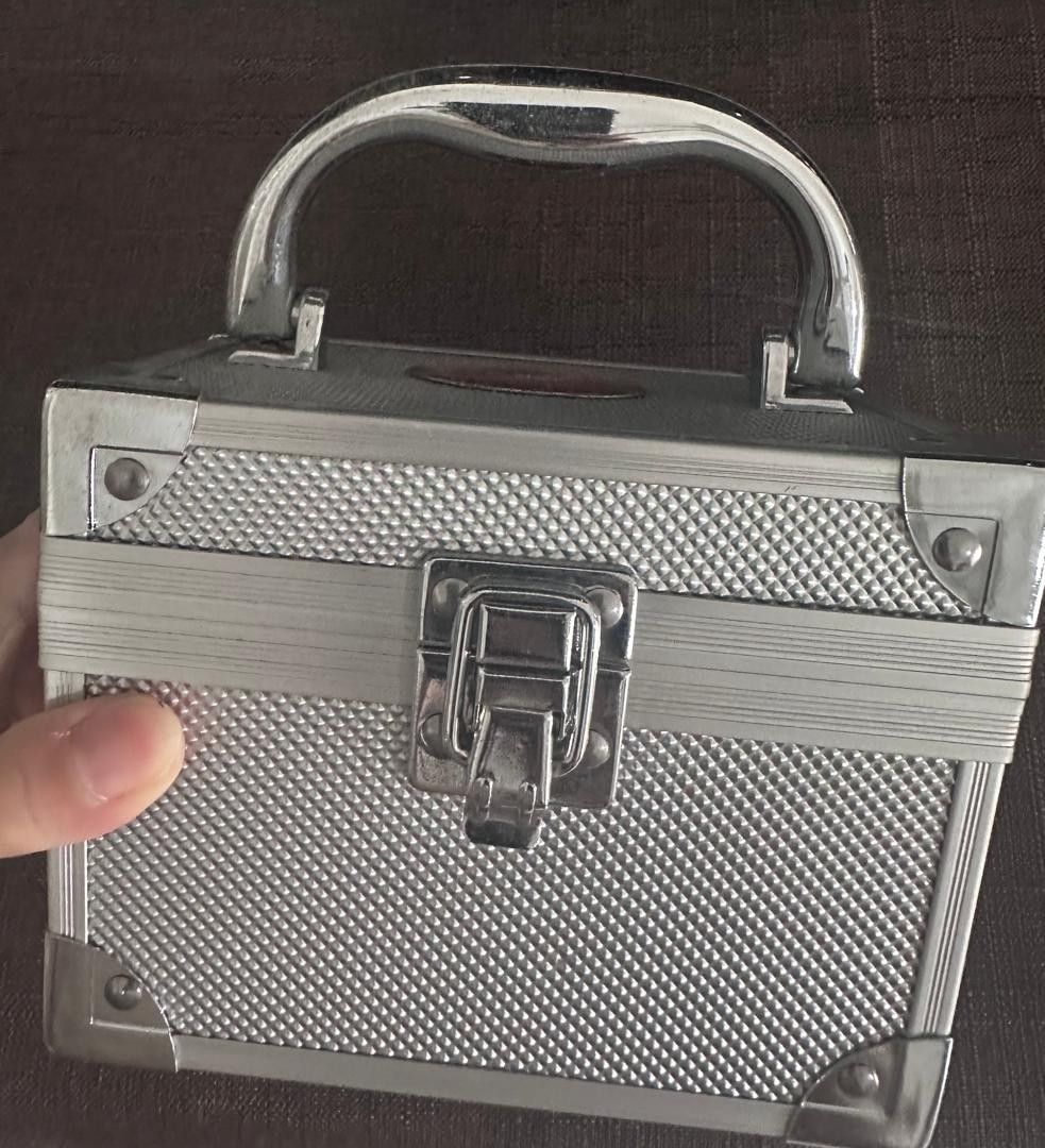Solid Silver Makeup Case with Mirror (Category: Accessory holder, box & organisers) located in Kuala Lumpur. Submitted by beauart59816 (Listing ID 1449305175, Image 2). Description: - Sleek silver makeup case - Features a convenient handle and secure latch closure. - Interior includes a built-in mirror and plush black velvet lining. - Handy small elastic pocket for extra storage. - Ideal for organizing makeup, jewelry, or small accessories. - Com
