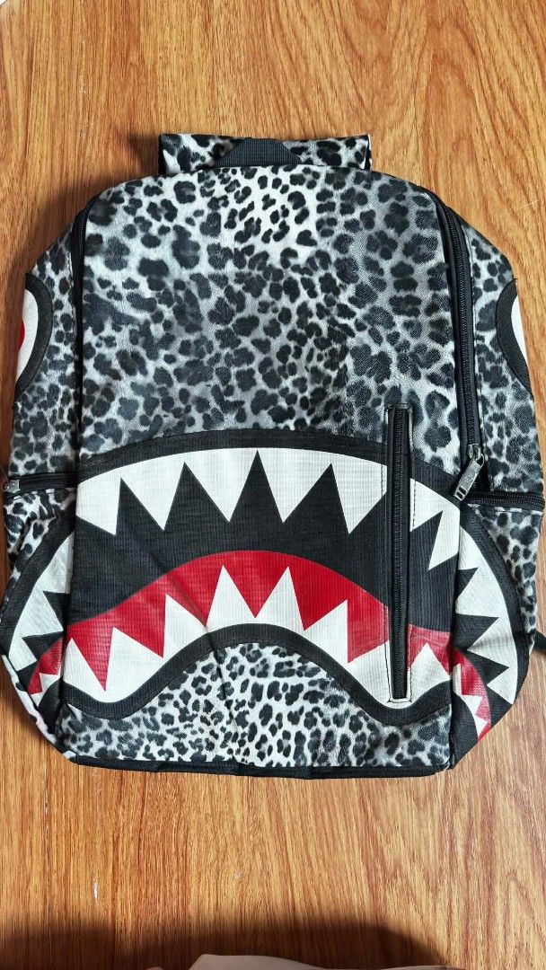 Sprayground Shark Mouth Leopard Print Backpack (Category: Backpacks) located in Manila. Submitted by ruane_raleigh12 (Listing ID 1449285633, Image 1). Description: - Unique shark mouth design - All-over leopard print - Convenient front zipper pocket - Ideal for school or everyday use - Makes a bold fashion statement.