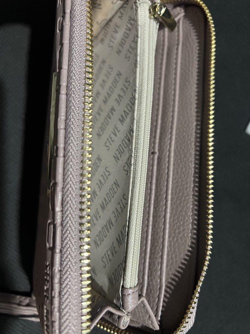 Steve Madden Mauve Large Zip Around Wallet (Category: Luxury Bags & Wallets) located in Manila. Submitted by kldeclutter (Listing ID 1449259874, Image 3). Description: - Brand: Steve Madden - Color: Mauve - Style: Zip around wallet - Features: All-over embossed logo pattern, attached wrist strap - Interior: Plenty of card slots, zippered compartment - Condition: New with original tag - Original Price: $44.00.