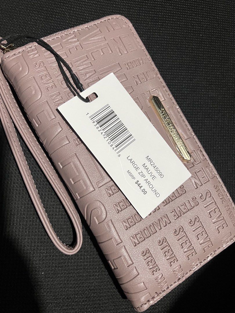 Steve Madden Mauve Large Zip Around Wallet (Category: Luxury Bags & Wallets) located in Manila. Submitted by kldeclutter (Listing ID 1449259874, Image 2). Description: - Brand: Steve Madden - Color: Mauve - Style: Zip around wallet - Features: All-over embossed logo pattern, attached wrist strap - Interior: Plenty of card slots, zippered compartment - Condition: New with original tag - Original Price: $44.00.