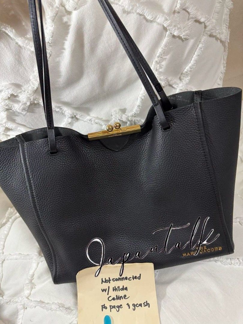 The Marc Jacobs Black Leather Tote Bag (Category: Luxury Bags & Wallets) located in Bulacan. Submitted by vintage_purge (Listing ID 1449135597, Image 1). Description: - Brand: The Marc Jacobs - Material: Black pebbled leather - Closure: Gold-tone clasp at the top - Features: Large embossed logo on the front - Interior: Spacious, ideal for essentials - Style: Great everyday bag.