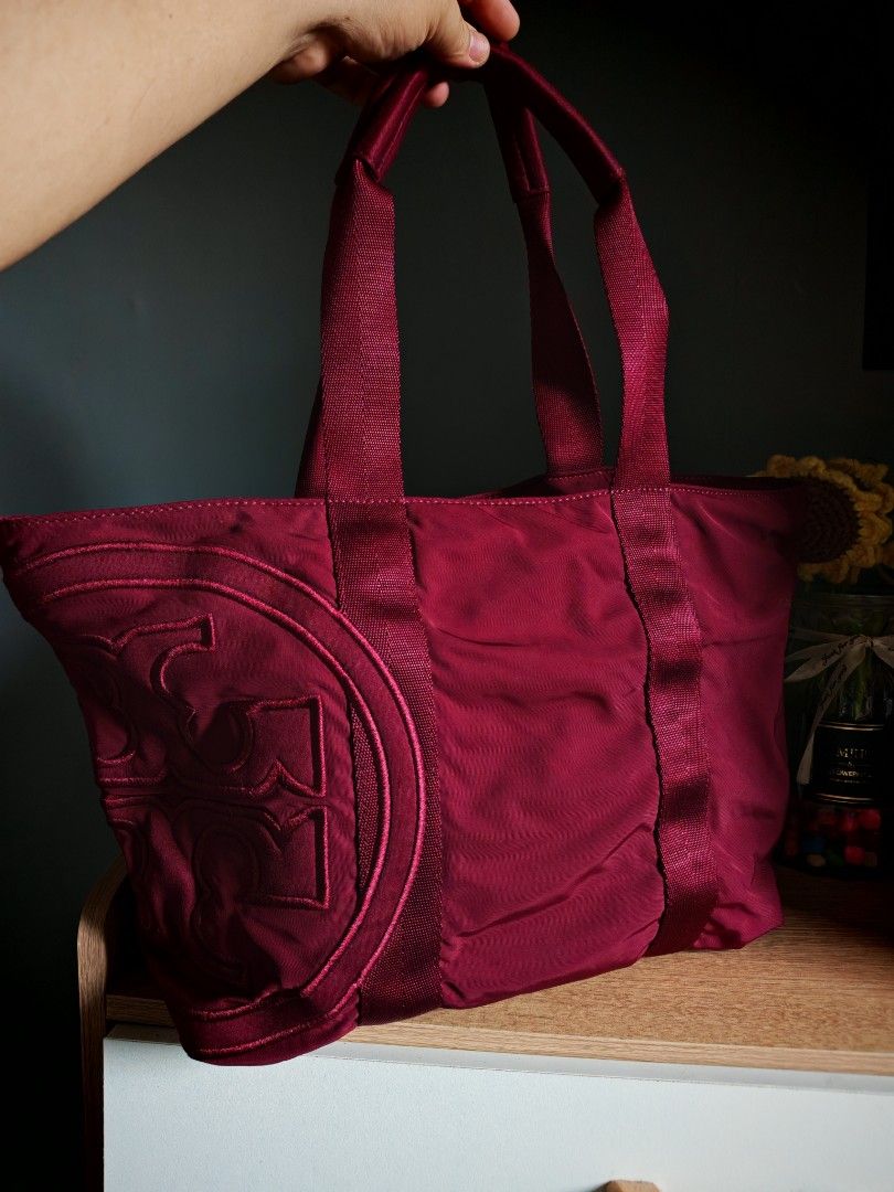 Tory Burch Burgundy Nylon Tote Bag (Category: Luxury Bags & Wallets) located in Manila. Submitted by cleverwhale_45b7bc (Listing ID 1449199672, Image 1). Description: - Stylish burgundy Tory Burch tote bag - Durable nylon material - Signature Tory Burch logo embossed on the front - Gold hardware with branded zipper pull - Spacious interior, ideal for everyday use - Sturdy and comfortable handles.