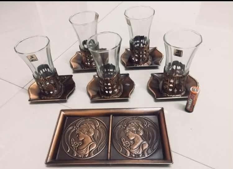 Vintage Tea Glasses Set with Tray (Category: Other Kitchenware & Tableware) located in Caloocan City. Submitted by shiela131538193 (Listing ID 1449252618, Image 2). Description: - Set of 6 vintage tea glasses - Unique hexagonal shape - Decorative metal holders with bronze-like finish - Matching tray with embossed female profiles - Ideal for serving tea or coffee - Adds a retro touch to your home decor.