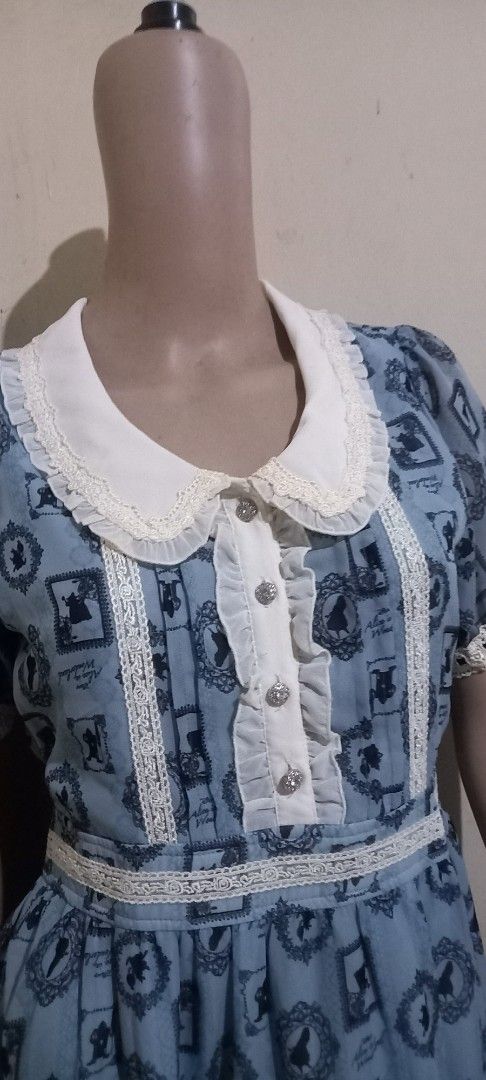 Blue patterned dress with white lace trim (Category: Dresses) located in San Pablo. Submitted by lheyab (Listing ID 1449343415, Image 2). Description: Axes Femme x Alice in Wonderland cut tags - Cute blue dress with a repeating pattern - White lace details on collar, sleeves, and hem - Ruffled front with button closure - Short sleeves - Vintage-inspired style.