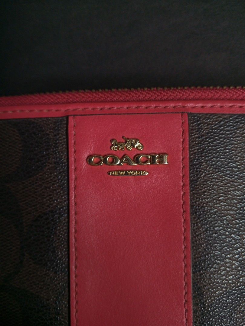 Coach Signature Zip Around Wallet (Category: Wallets & Card holders) located in Las Pinas. Submitted by allhandpick (Listing ID 1449389741, Image 2). Description: - Authentic Coach wallet in signature print - Color: Brown with a distinctive red stripe down the middle - Secure zip-around closure - Elegant gold hardware - Ample interior space for cards and cash - Ideal for everyday use and organization.
