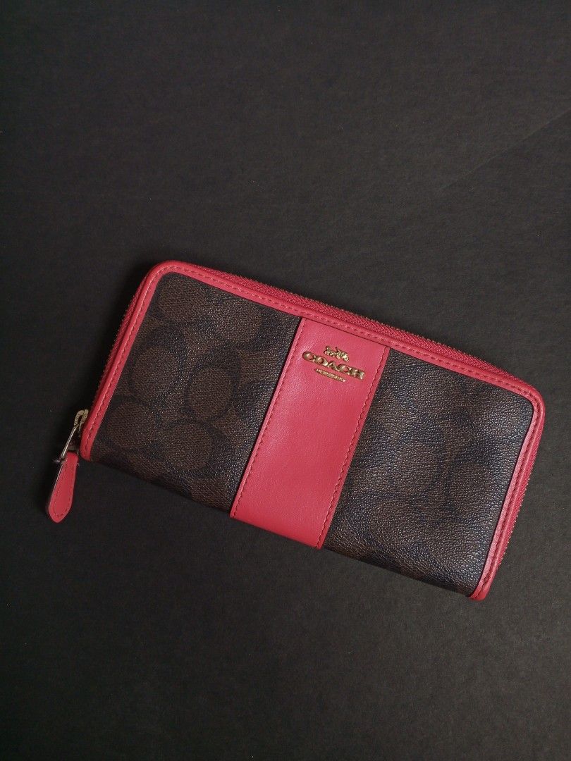 Coach Signature Zip Around Wallet (Category: Wallets & Card holders) located in Las Pinas. Submitted by allhandpick (Listing ID 1449389741, Image 1). Description: - Authentic Coach wallet in signature print - Color: Brown with a distinctive red stripe down the middle - Secure zip-around closure - Elegant gold hardware - Ample interior space for cards and cash - Ideal for everyday use and organization.
