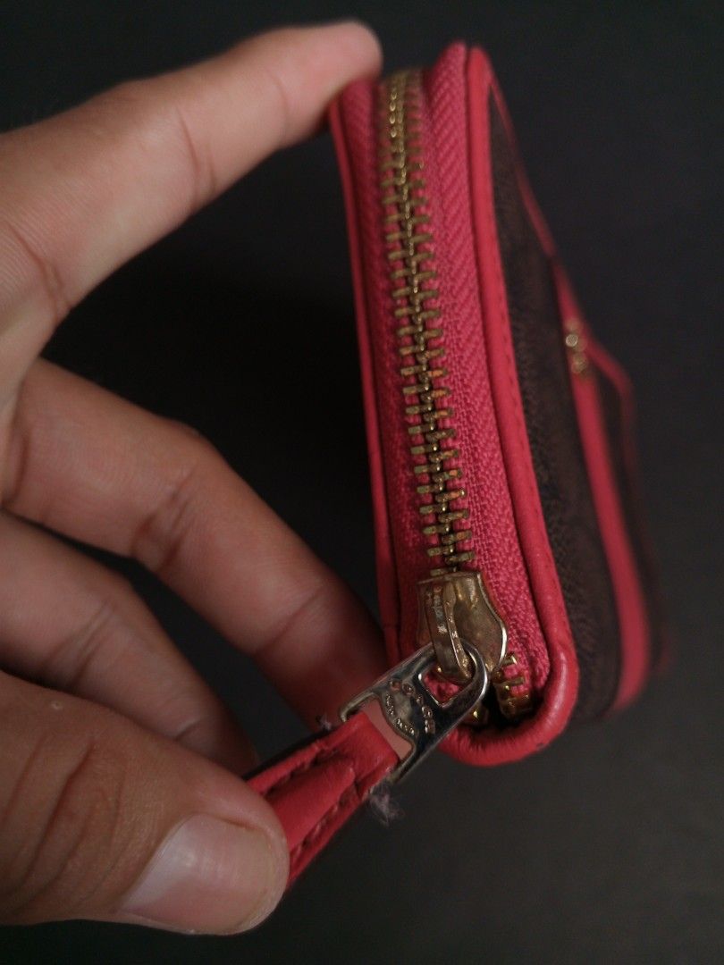 Coach Signature Zip Around Wallet (Category: Wallets & Card holders) located in Las Pinas. Submitted by allhandpick (Listing ID 1449389741, Image 3). Description: - Authentic Coach wallet in signature print - Color: Brown with a distinctive red stripe down the middle - Secure zip-around closure - Elegant gold hardware - Ample interior space for cards and cash - Ideal for everyday use and organization.