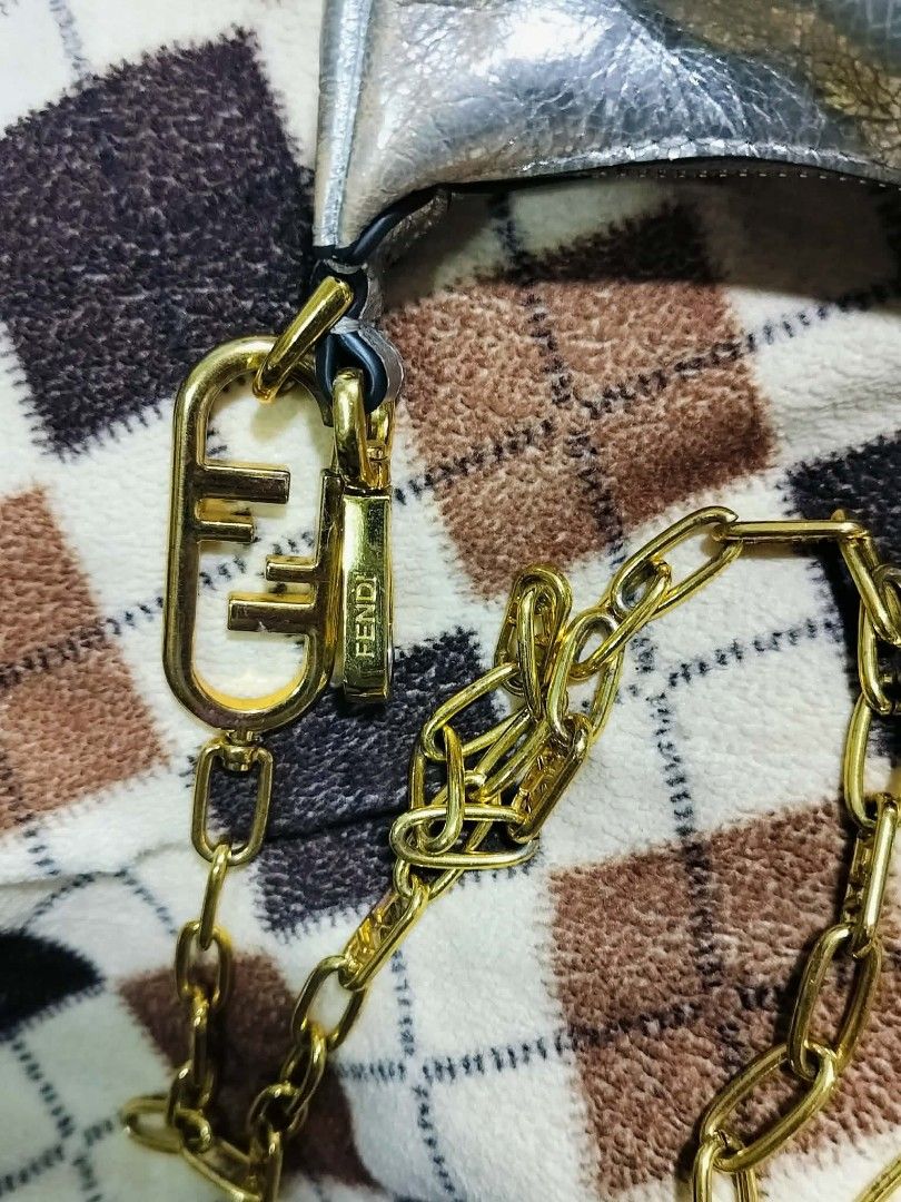 Fendi Moon Baguette Chain Bag Silver Metallic (Category: Luxury Bags & Wallets) located in Manila. Submitted by rose_onlineshop28 (Listing ID 1449424384, Image 3). Description: - Fendi Moon Bag - Color: Silver Metallic - Features iconic Fendi logo on the side - Stylish chain strap with Fendi logo clasp - Unique crescent shape - Interior tag with serial number - Ideal for night outs or adding a statement to your outfit.