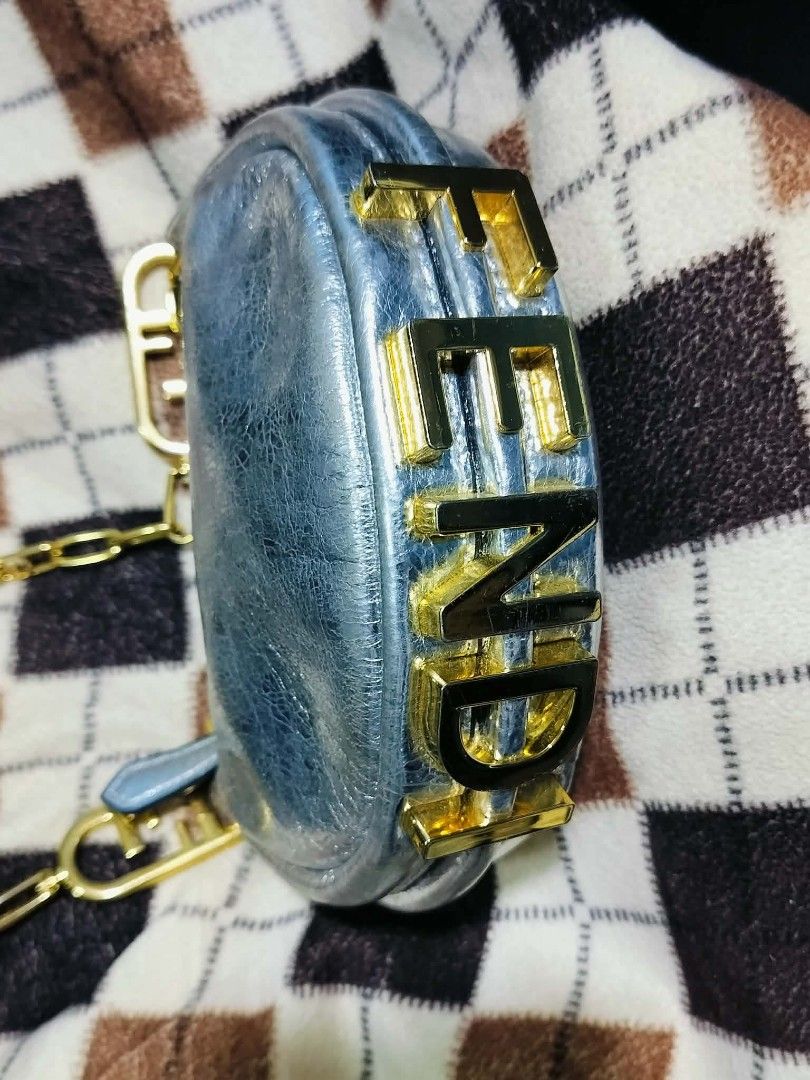 Fendi Moon Baguette Chain Bag Silver Metallic (Category: Luxury Bags & Wallets) located in Manila. Submitted by rose_onlineshop28 (Listing ID 1449424384, Image 2). Description: - Fendi Moon Bag - Color: Silver Metallic - Features iconic Fendi logo on the side - Stylish chain strap with Fendi logo clasp - Unique crescent shape - Interior tag with serial number - Ideal for night outs or adding a statement to your outfit.