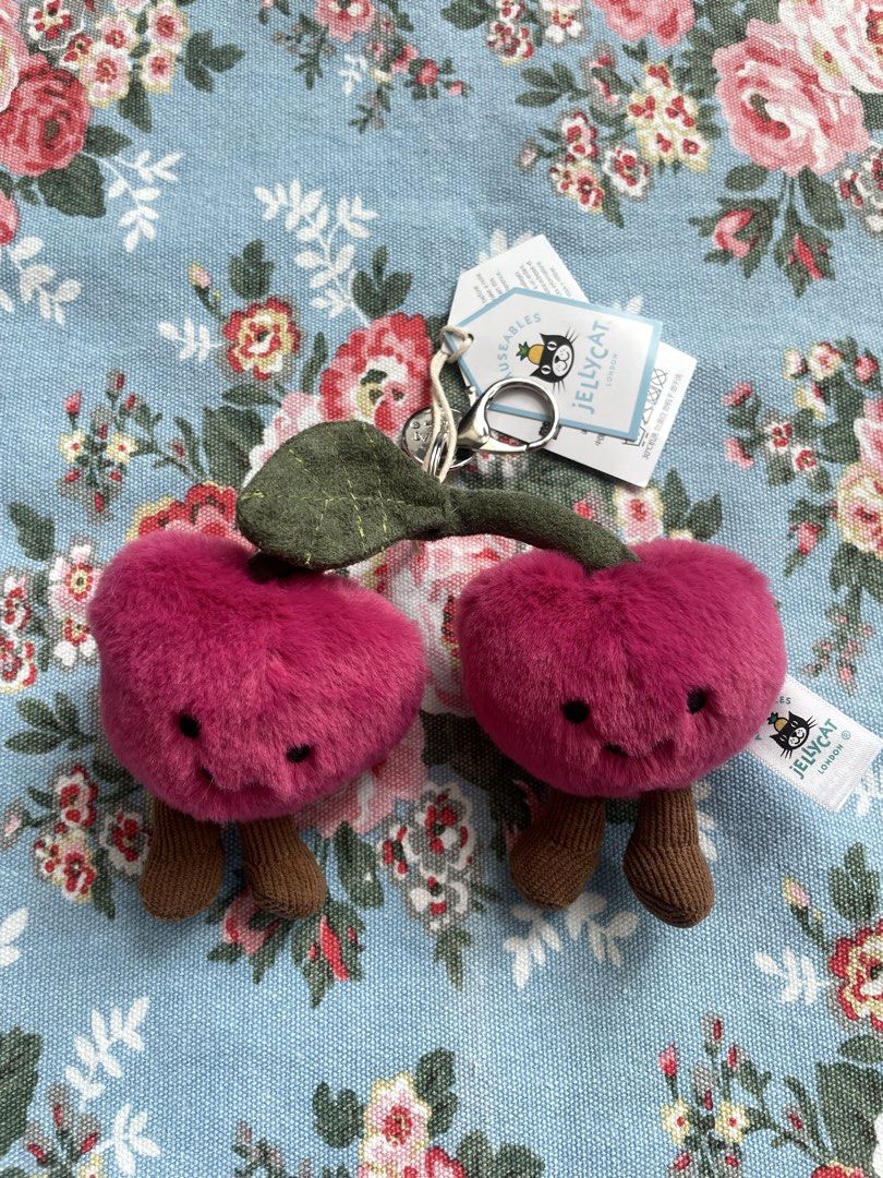 Jellycat Amuseables Cherries Bag Charm Keychain (Category: Plushies & Soft Toys) located in San Juan City. Submitted by nicheprincess (Listing ID 1449385562, Image 1). Description: - Super cute Jellycat Amuseables Cherries bag charm - Features two fluffy pink cherries with adorable faces - Includes brown stems - Comes with a metal keyring and clip for easy attachment - Perfect for adding a fun, playful touch to your bag or backpack - Brand new wi