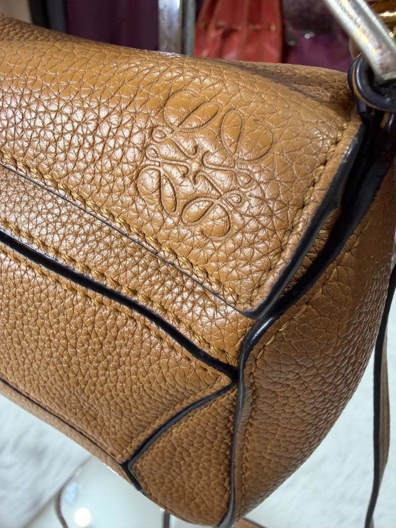 Loewe Puzzle Bag Tan Leather (Category: Luxury Bags & Wallets) located in Compostela. Submitted by thevintage92 (Listing ID 1449453558, Image 2). Description: - Authentic Loewe Puzzle bag - Color: Tan - Material: Pebble grain leather - Signature geometric paneling - Zipper closure - Detachable shoulder strap included - Interior: Loewe tag and 'Made in Spain' stamp - Ideal for everyday use.