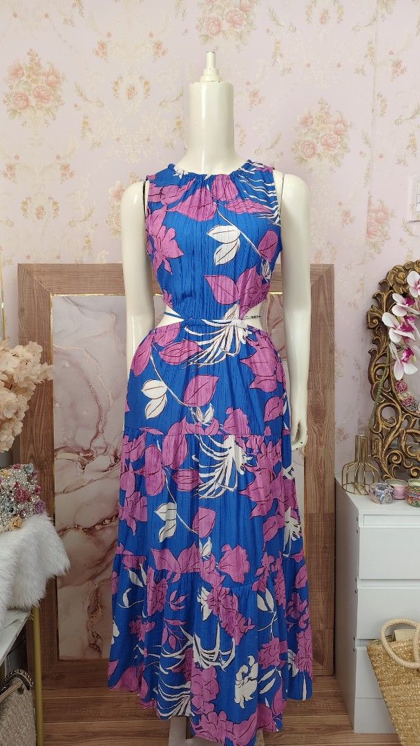 Mango Blue Floral Cutout Dress (Category: Dresses) located in Pagudpud. Submitted by altheacee063978 (Listing ID 1449389963, Image 2). Description: - fits s-m - Vibrant blue maxi dress - Bold pink floral print - Flattering cut-out details at the waist - Secure tie-back closure - Flowy tiered skirt for added movement - Sleeveless design - Ideal for summer outings or casual events.