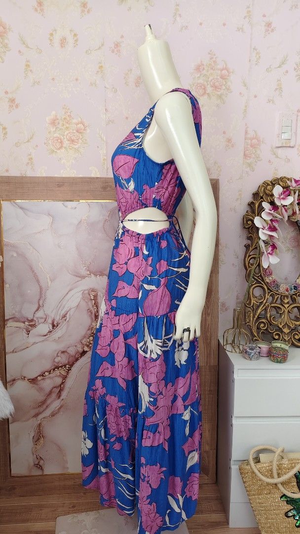 Mango Blue Floral Cutout Dress (Category: Dresses) located in Pagudpud. Submitted by altheacee063978 (Listing ID 1449389963, Image 3). Description: - fits s-m - Vibrant blue maxi dress - Bold pink floral print - Flattering cut-out details at the waist - Secure tie-back closure - Flowy tiered skirt for added movement - Sleeveless design - Ideal for summer outings or casual events.