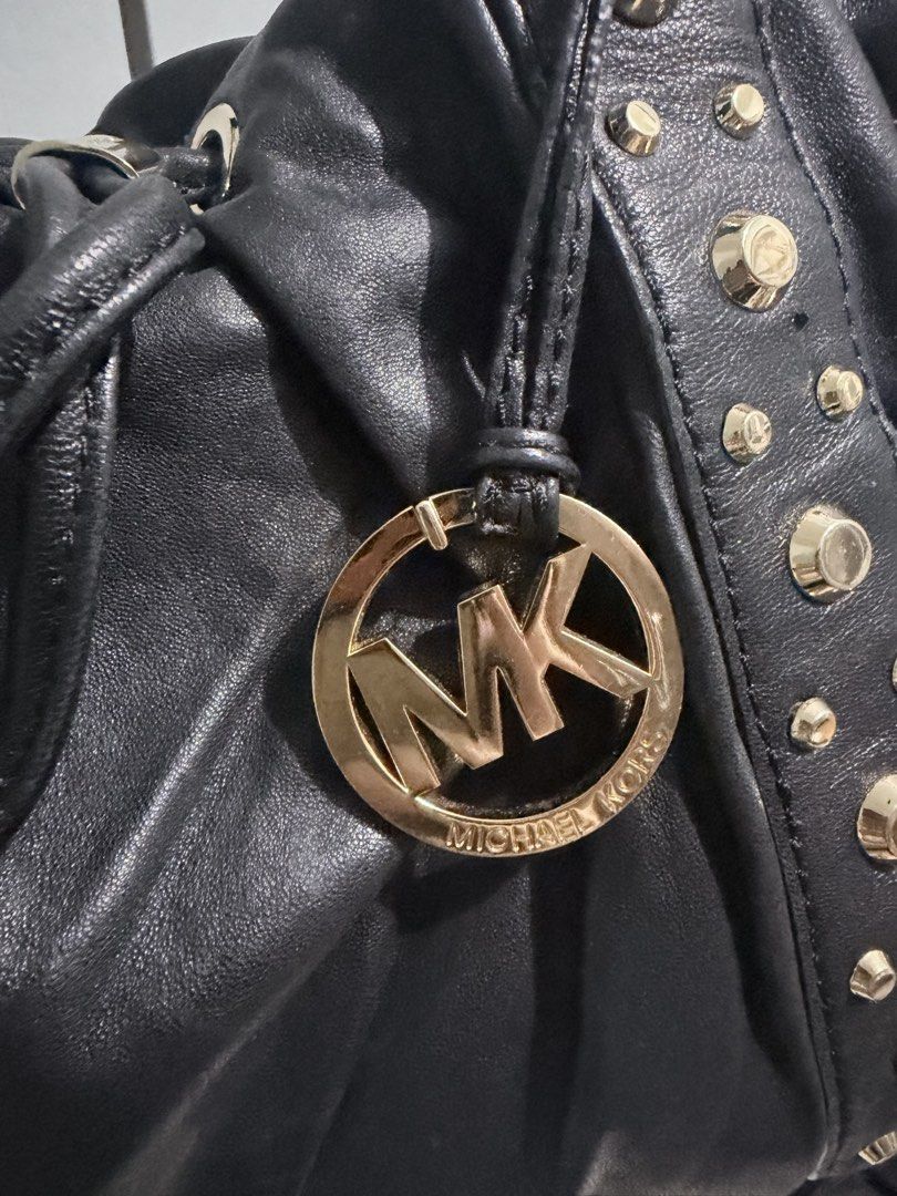 Michael Kors Ludlow Studded Leather Drawstring Shoulder Bag (Category: Luxury Bags & Wallets) located in Manila. Submitted by prelovedbygayle (Listing ID 1449477064, Image 3). Description: Vertical Stud Trim: Ornamented with vertical lines of distinct, highly polished dome-shaped gold studs flanking the front and back panel seams. Cinched Drawstring Design: Configured with a central leather drawstring pull-tab that allows the soft, buttery black 