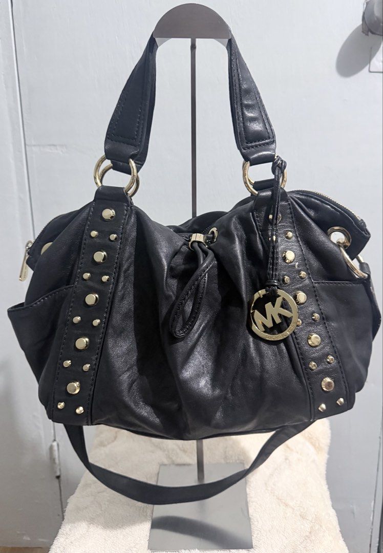 Michael Kors Ludlow Studded Leather Drawstring Shoulder Bag (Category: Luxury Bags & Wallets) located in Manila. Submitted by prelovedbygayle (Listing ID 1449477064, Image 1). Description: Vertical Stud Trim: Ornamented with vertical lines of distinct, highly polished dome-shaped gold studs flanking the front and back panel seams. Cinched Drawstring Design: Configured with a central leather drawstring pull-tab that allows the soft, buttery black 