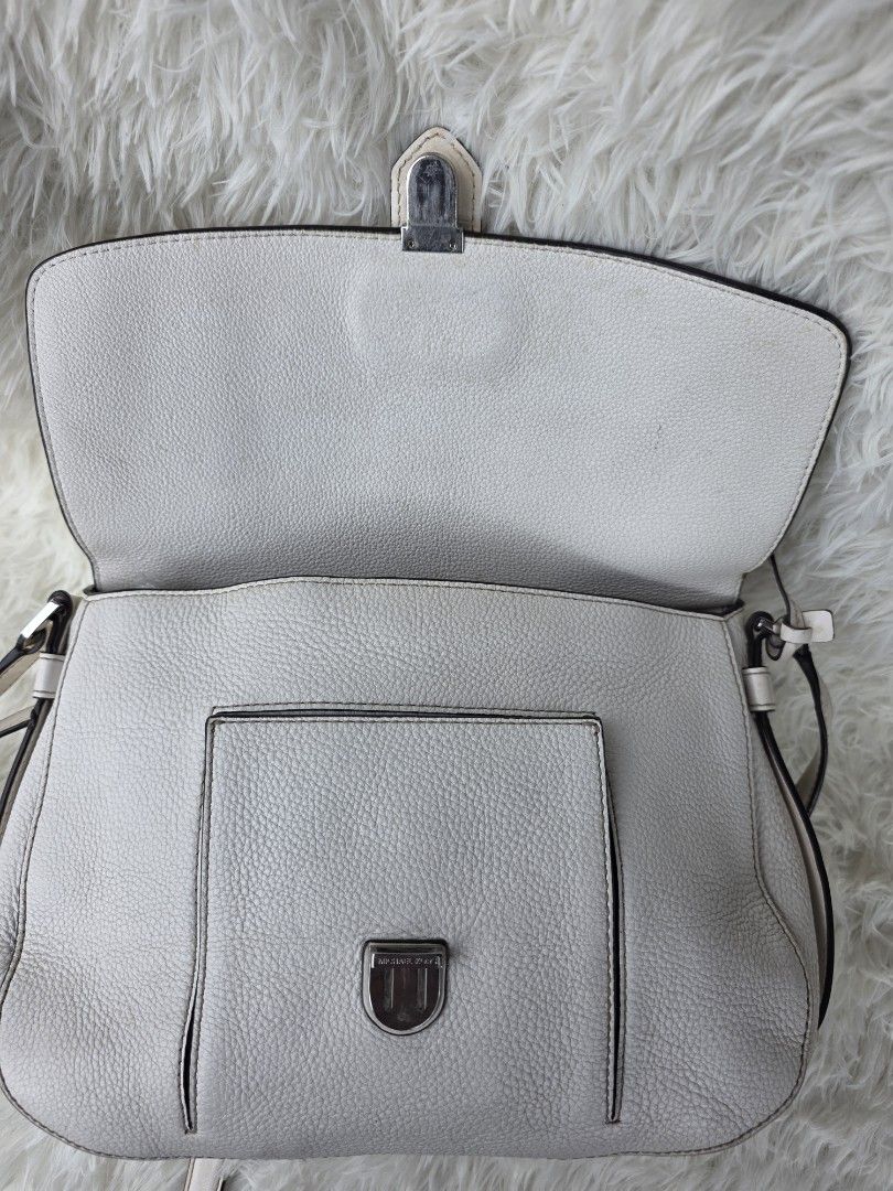 Michael Kors White Leather Satchel Handbag (Category: Luxury Bags & Wallets) located in Lemery. Submitted by venus23 (Listing ID 1449356003, Image 2). Description: - Michael Kors white leather satchel bag - Versatile with top handles and a detachable shoulder strap - Secure front buckle closure - Convenient back zip pocket - Organized interior with multiple pockets and a key clip.
