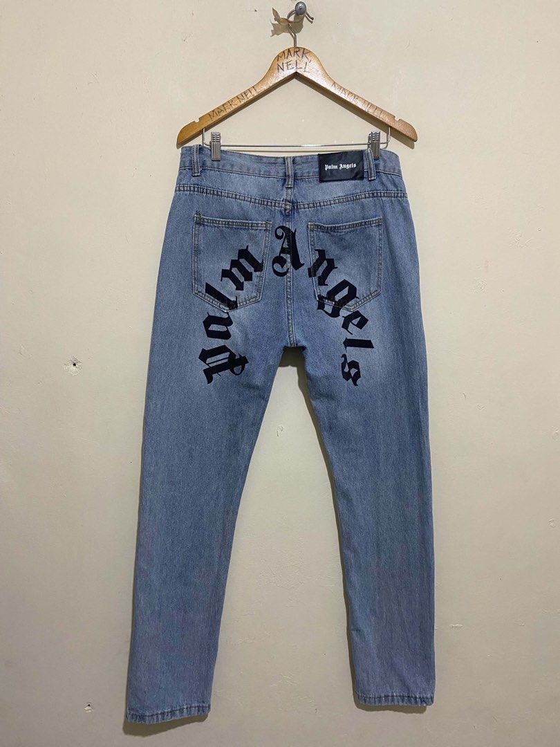 Palm Angels Light Wash Denim Jeans (Category: Jeans) located in Caloocan City. Submitted by mrknll (Listing ID 1449344311, Image 2). Description: - Brand: Palm Angels - Wash: Light wash denim - Fit: Straight leg - Details: Signature gothic logo on back, classic five-pocket styling - Closure: Button and zip fly - Occasion: Casual wear.
