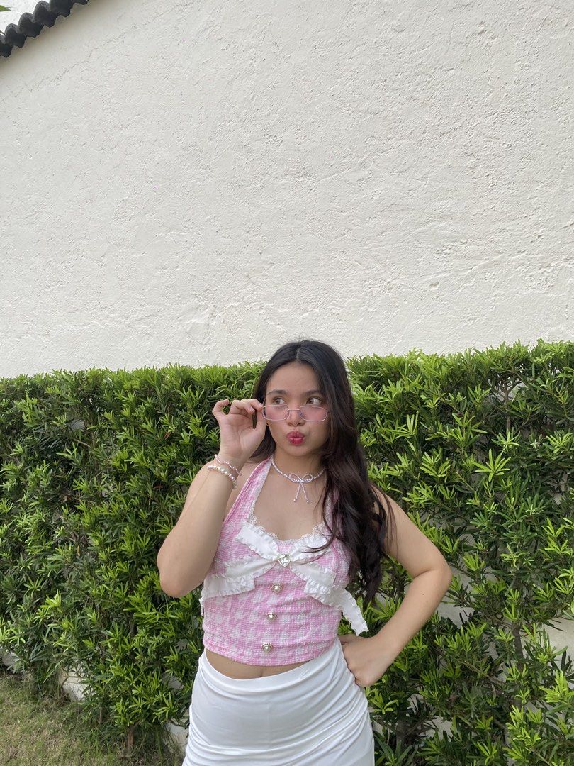 Pink Houndstooth Halter Top with Bow Detail (Category: Sleeveless) located in Dasmarinas. Submitted by hellojoena (Listing ID 1449445473, Image 1). Description: - Adorable pink houndstooth halter top - Features a ruched bust with delicate white lace trim - Sweet bow detail at the bust - Functional pearl buttons down the front - Flattering cropped silhouette - Ideal for summer outfits, parties, or casual outings.