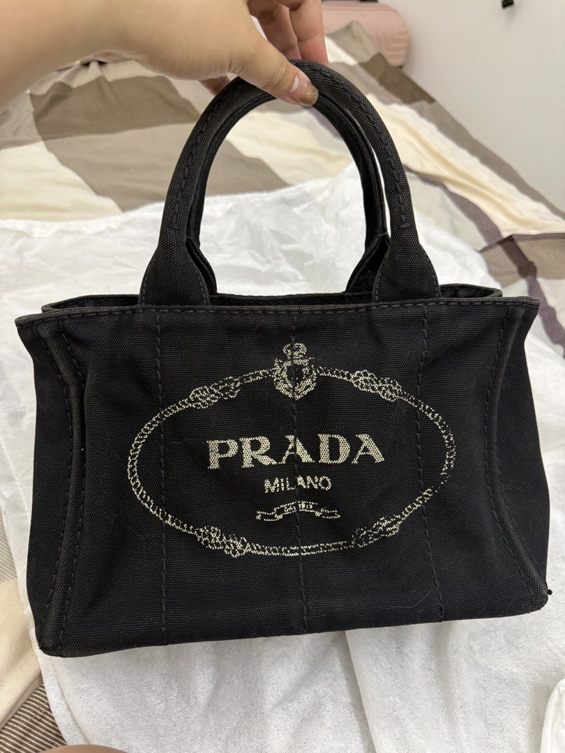 Prada Black Canapa Tote Bag (Category: Luxury Bags & Wallets) located in Binan City. Submitted by resasanmig (Listing ID 1449470237, Image 2). Description: - Authentic Prada tote bag - Black canvas material - Iconic Prada logo on the front - Gold hardware details - Spacious interior, great for essentials - Perfect for everyday use - no inclusions .