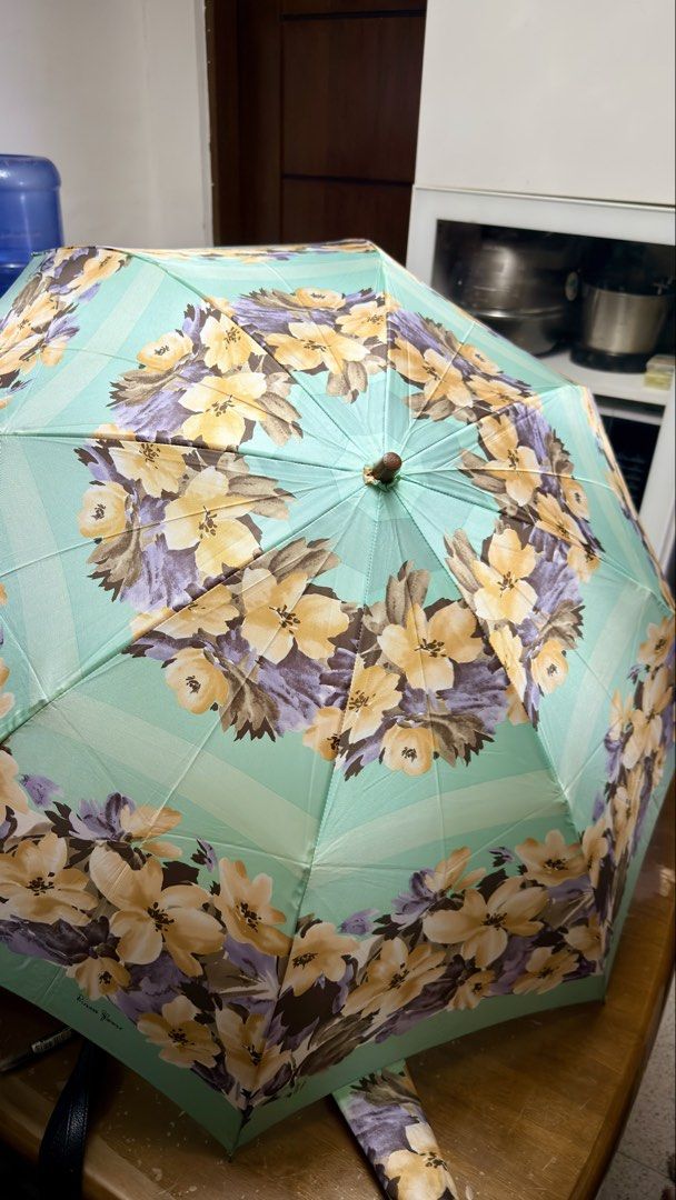 Princess Florence Floral Umbrella (Category: Umbrellas) located in Pilar. Submitted by faveanyshop (Listing ID 1449412882, Image 1). Description: - Pretty mint green umbrella - Lovely floral print with yellow and purple flowers - 'Princess Florence' brand visible - Features a wooden handle - Includes a convenient wrist strap - Folds up compactly for easy storage - Ideal for rainy days or as a stylish accessory - nylon material.