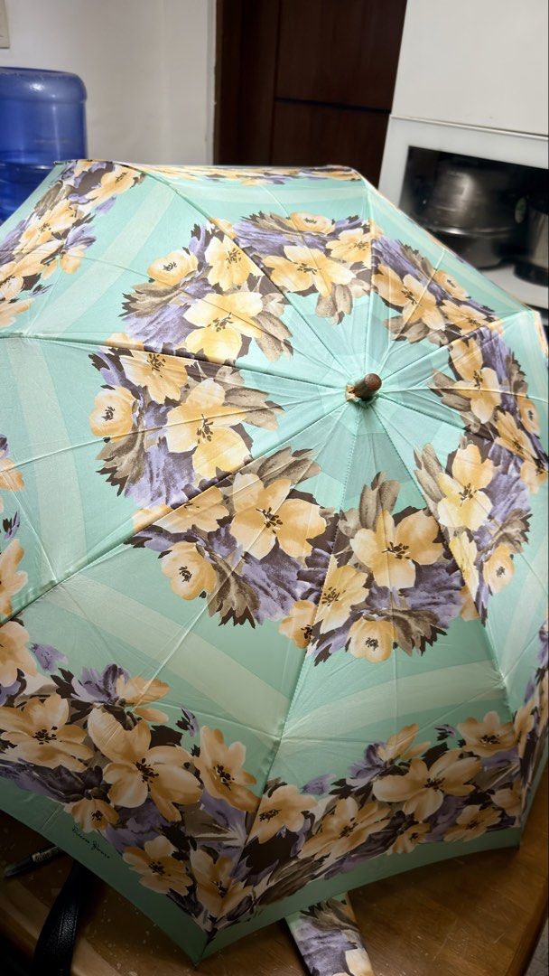 Princess Florence Floral Umbrella (Category: Umbrellas) located in Pilar. Submitted by faveanyshop (Listing ID 1449412882, Image 2). Description: - Pretty mint green umbrella - Lovely floral print with yellow and purple flowers - 'Princess Florence' brand visible - Features a wooden handle - Includes a convenient wrist strap - Folds up compactly for easy storage - Ideal for rainy days or as a stylish accessory - nylon material.
