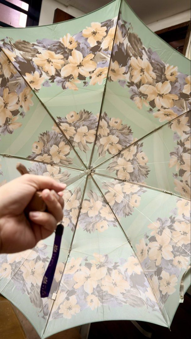 Princess Florence Floral Umbrella (Category: Umbrellas) located in Pilar. Submitted by faveanyshop (Listing ID 1449412882, Image 3). Description: - Pretty mint green umbrella - Lovely floral print with yellow and purple flowers - 'Princess Florence' brand visible - Features a wooden handle - Includes a convenient wrist strap - Folds up compactly for easy storage - Ideal for rainy days or as a stylish accessory - nylon material.