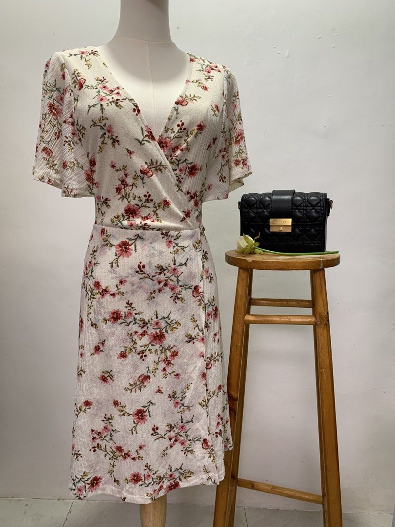 Springfield Floral Wrap Midi Dress (Category: Dresses) located in Las Pinas. Submitted by deargiya (Listing ID 1449509496, Image 1). Description: Medida Sizing: Bust: 36 Waist: 30 Length: 36 - White midi dress with a pretty floral print - Flattering wrap style - Comfortable flutter sleeves - Subtle textured fabric - Perfect for casual outings or dressing up - Ideal for spring and summer wear Loc: Las Piñas City MOP: gcash / bank transfer MOD: Lal
